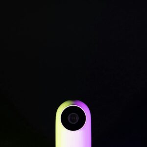 Home Sleek white webcam on a black background with neon lighting, emphasizing technology and modern design.